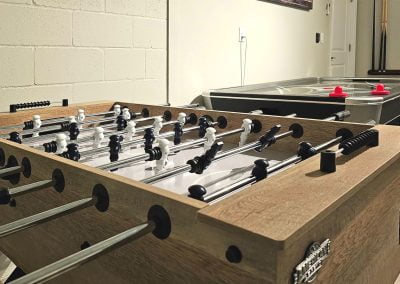 Foosball table and air hockey table in the game room with air conditioning