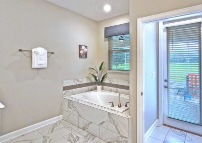Primary Bathroom on the ground floor has double sinks, soaking tub, shower, separate WC and access to the pool area.