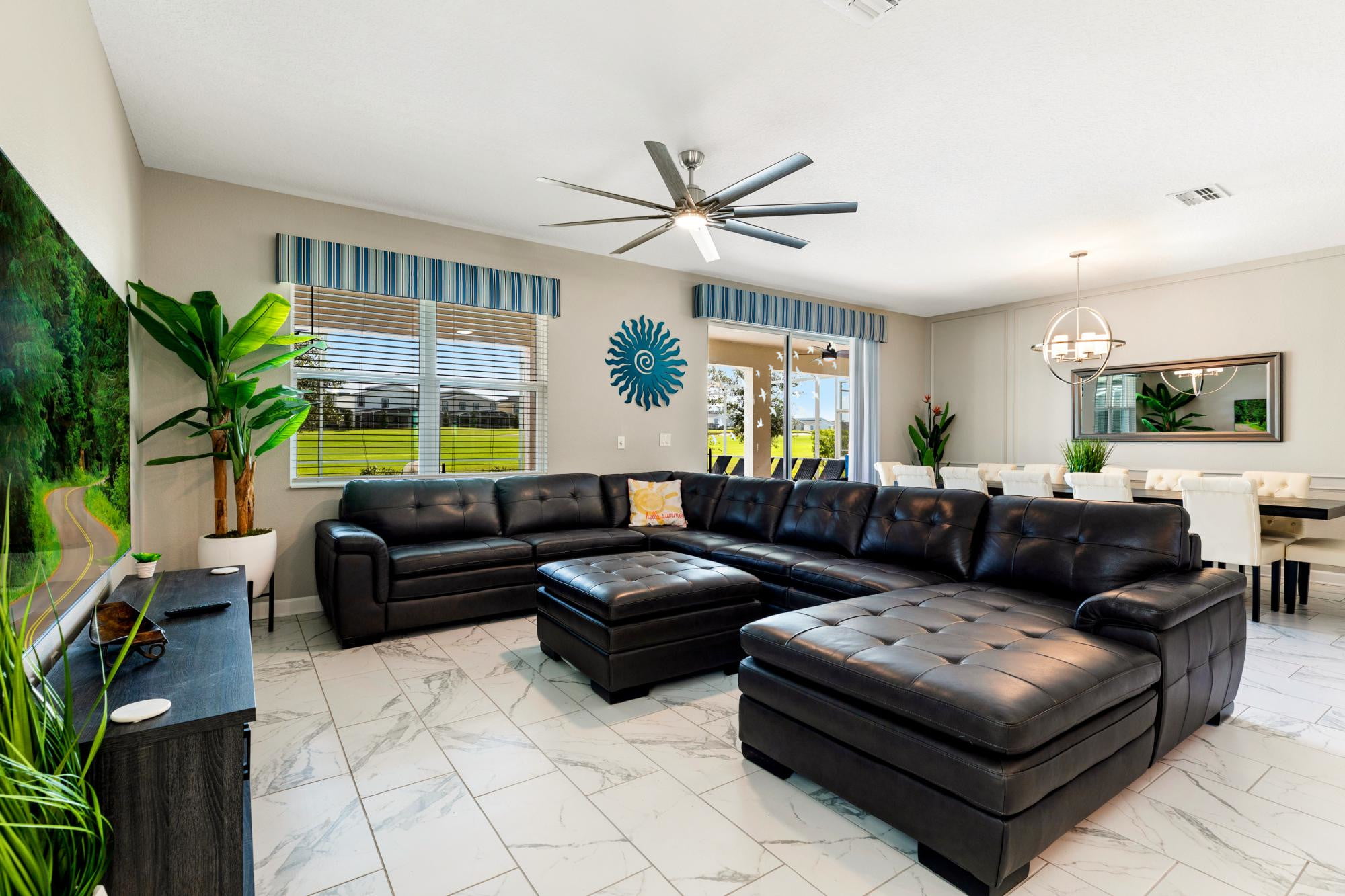 Living room - Huge 85 inch Smart TV, large leather sectional and a view of the saltwater pool