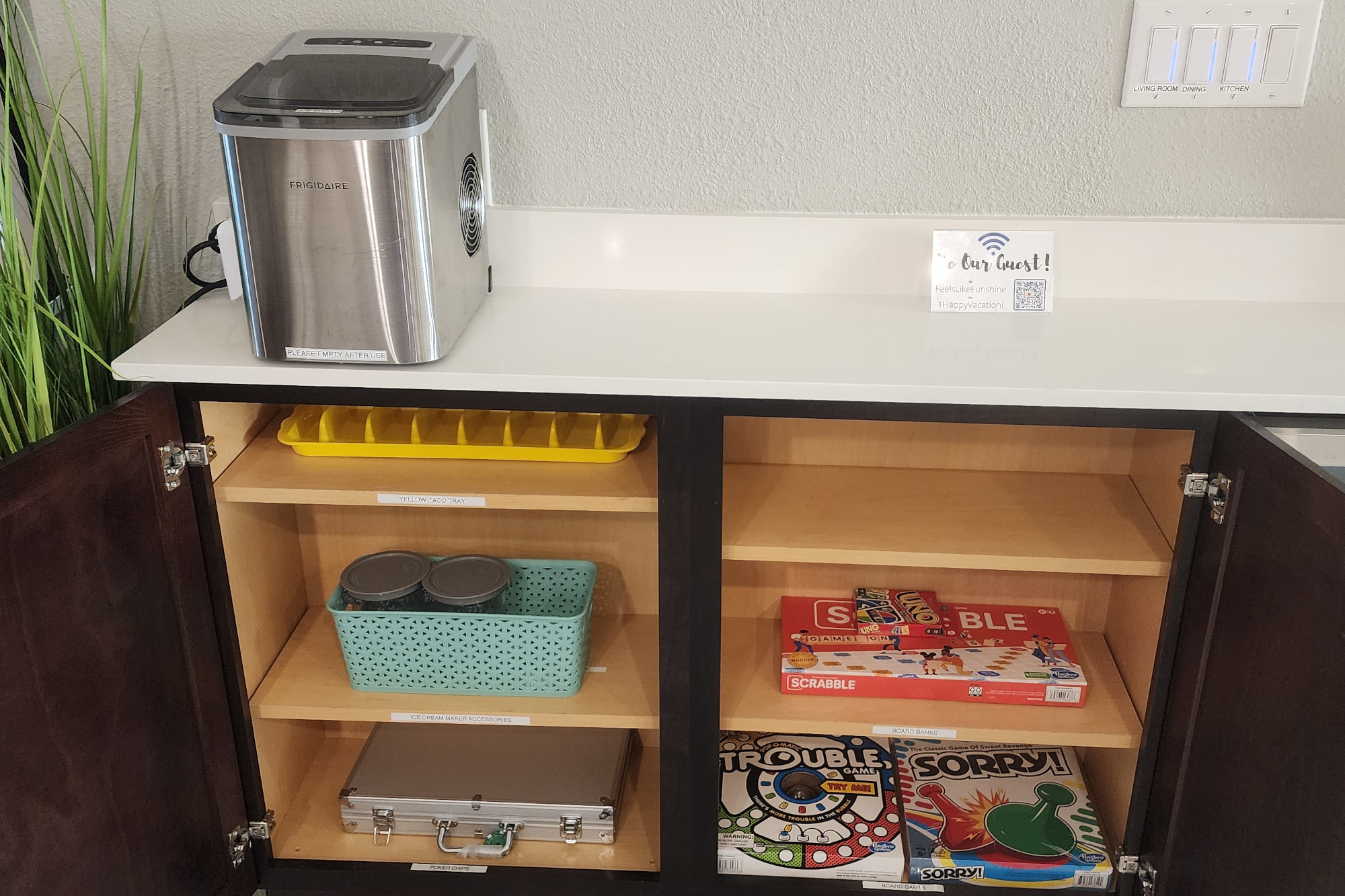 The soft serve ice cream accessories are located in a green basket in the kitchen cabinet directly under the countertop ice maker